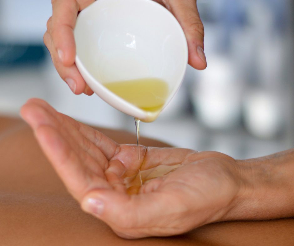 Warmes Massageöl, das in einer Hand fließt.